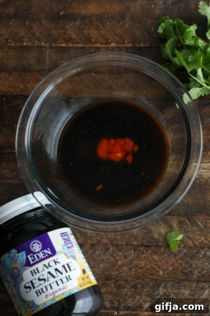 Midnight Sesame Noodle Bowl 4 Ingredients for Black Sesame Butter sauce in a bowl, featuring the dark, rich black sesame butter.