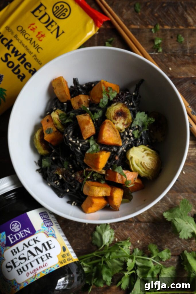 Midnight Sesame Noodle Bowl 9 Black Sesame Noodle Bowl served in a bowl, garnished with cilantro and sesame seeds.