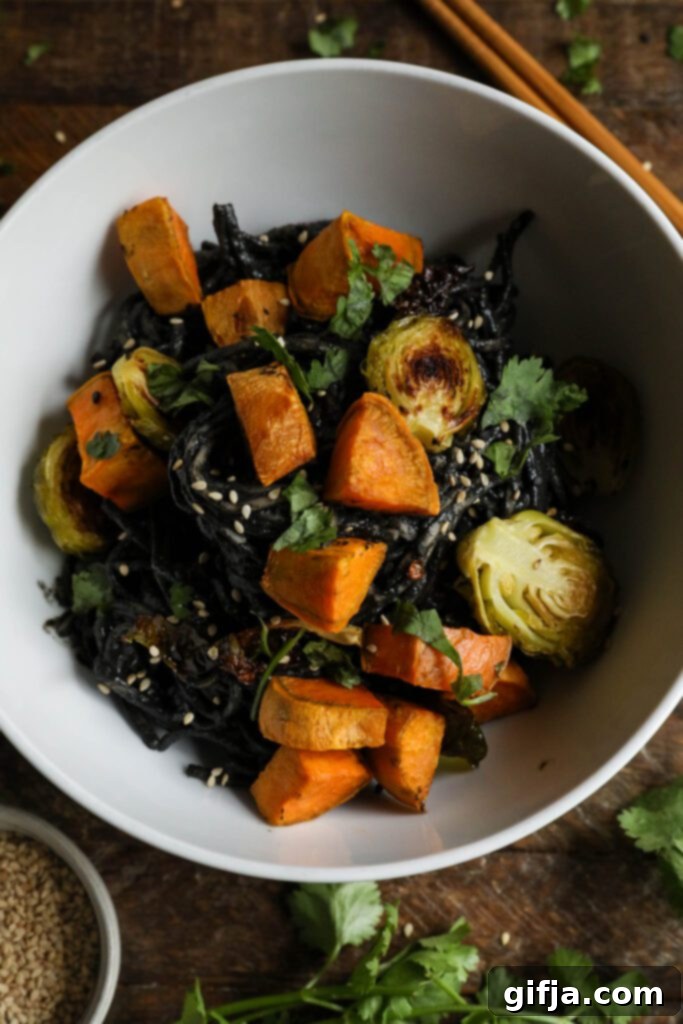 Midnight Sesame Noodle Bowl 10 Black Sesame Noodle Bowl served in a bowl, garnished with cilantro and sesame seeds, shown from a slightly different angle.