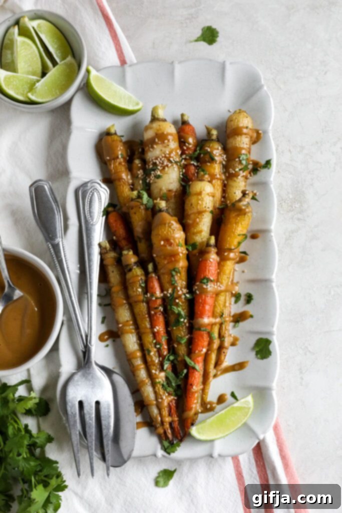 Rainbow Roasted Carrots with SunButter Sauce served on rectangular platter with fork and spoon and lime 