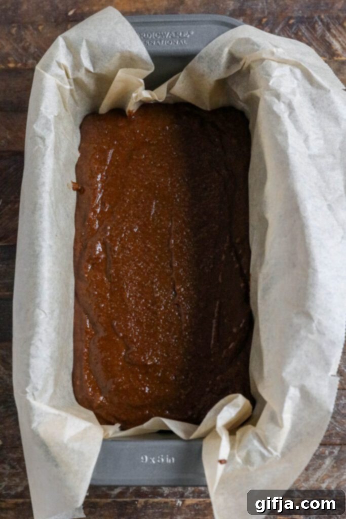 Applesauce Gingerbread Loaf batter in parchment lined loaf pan