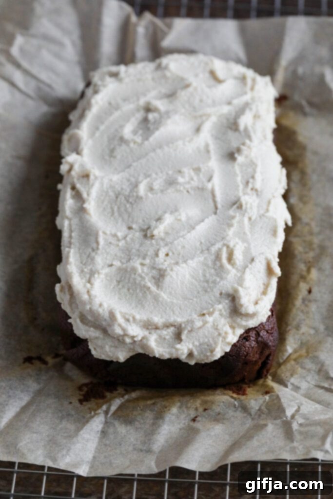 Applesauce Gingerbread Loaf frosted on parchment lined cooling rack